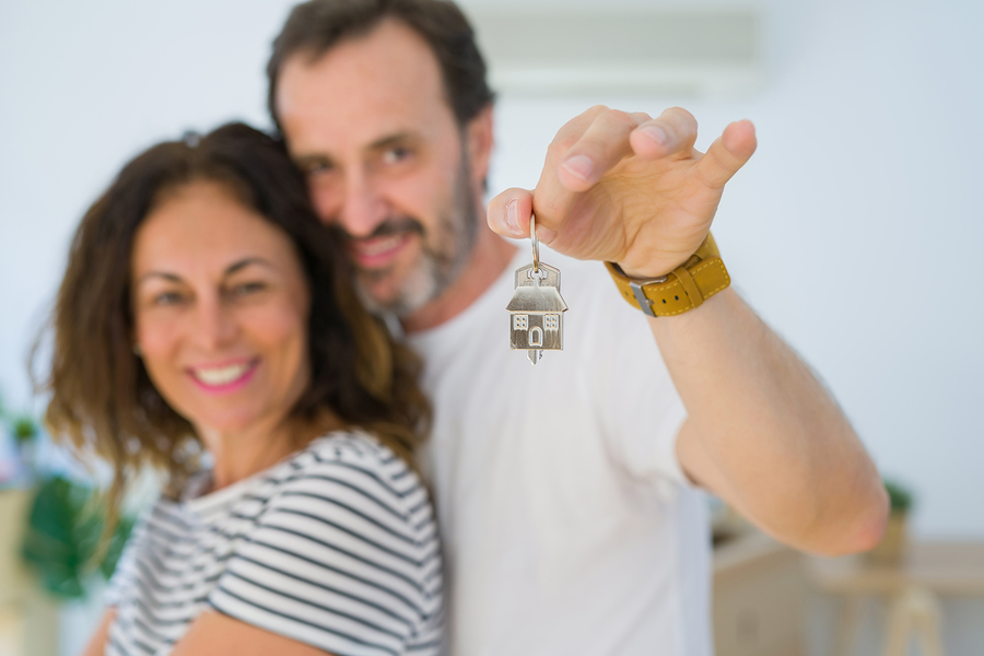 Middle Age Senior Romantic Couple Holding And Showing House Keys